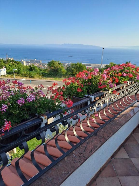 a row of benches filled with flowers with the ocean in the background at Eko Eko in Rijeka
