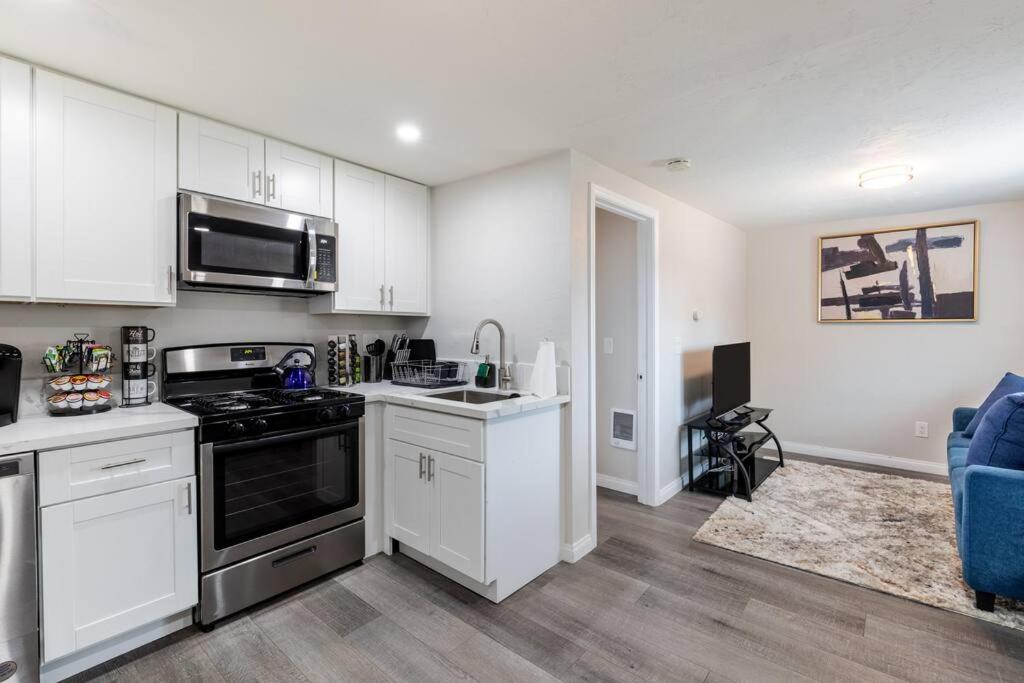 uma cozinha com armários brancos e um forno com placa de fogão em San Diego's Cozy Gem em San Diego
