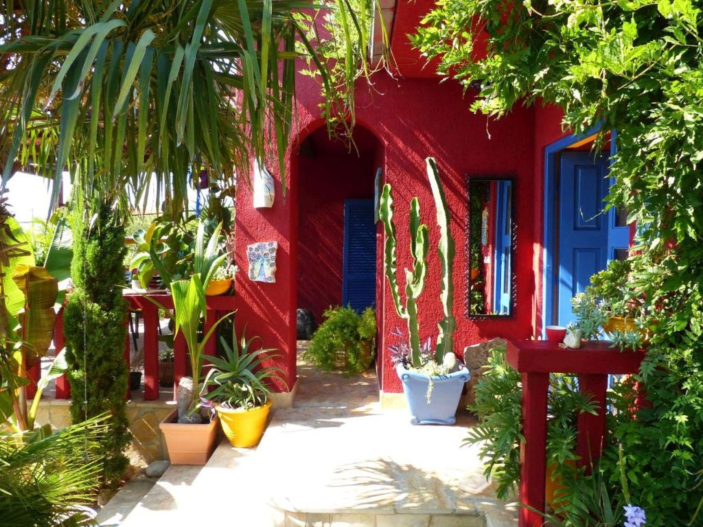 a red building with plants and a blue door at Villa Tropica, total privacy, tropical garden and private pool in Kaštela