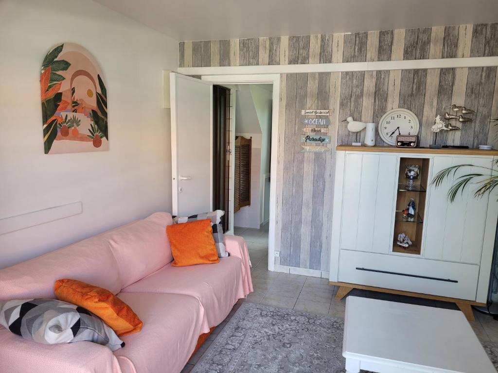 - un salon avec un canapé rose et une table dans l'établissement Cosy one-bedroom apartment in De Haan, au Coq