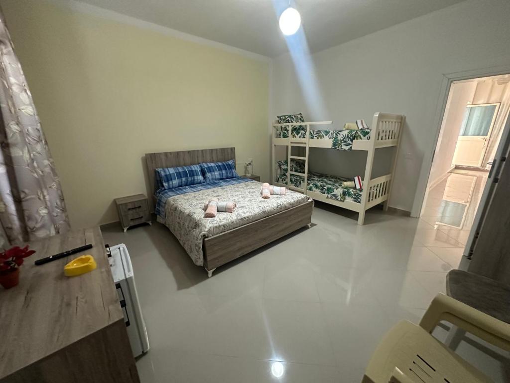 um pequeno quarto com uma cama e um berço em Home Anxhelo em Durrës