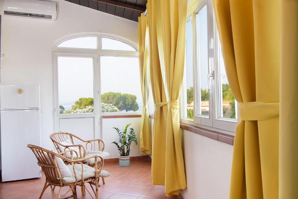 Zimmer mit einem Tisch, Stühlen und einem Fenster in der Unterkunft Simonelli Apartments in Ischia