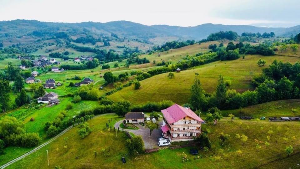 PENSIUNEA PLAI STRABUN في Strîmtura: اطلالة جوية على منزل في حقل اخضر