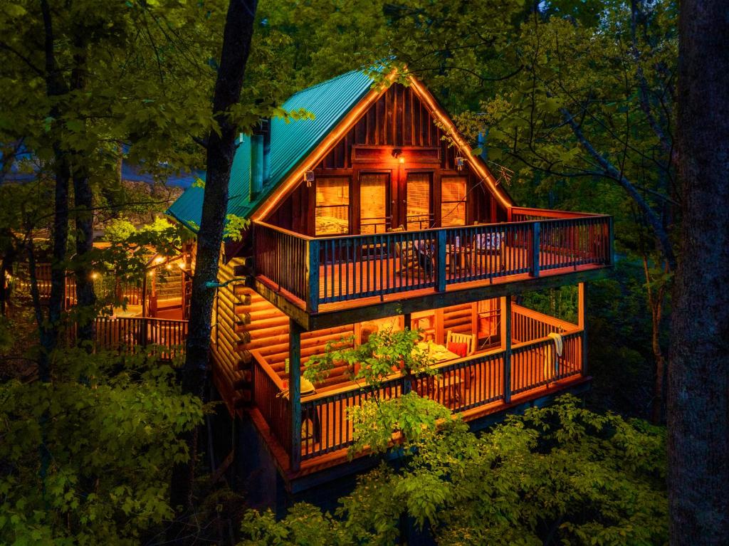 a tree house in the woods at night at CABIN in a GATED RESORT with SEASONAL RESORT POOL in Pigeon Forge