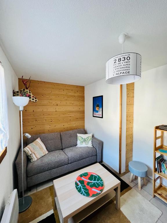 un salon avec un canapé et une table dans l'établissement Serre Chevalier, appartement T3, 4 personnes plein sud avec balcon, près des pistes, Meublé touristique 3 étoiles, à La Salle Les Alpes
