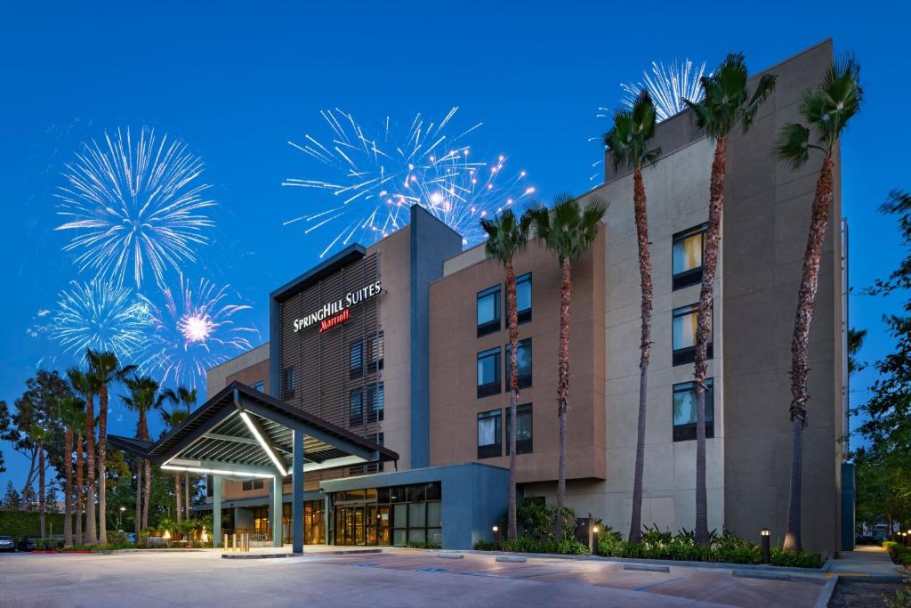 a hotel with palm trees and fireworks in the sky at Springhill Suites by Marriott Anaheim Maingate in Anaheim