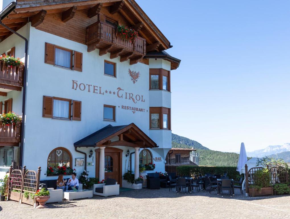a hotel with people sitting outside of it at Hotel Tirol- Natural Idyll in Montesover