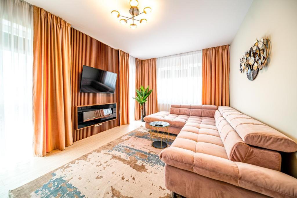 a living room with a couch and a television at Pink Velvet RK Ghimbav in Ghimbav