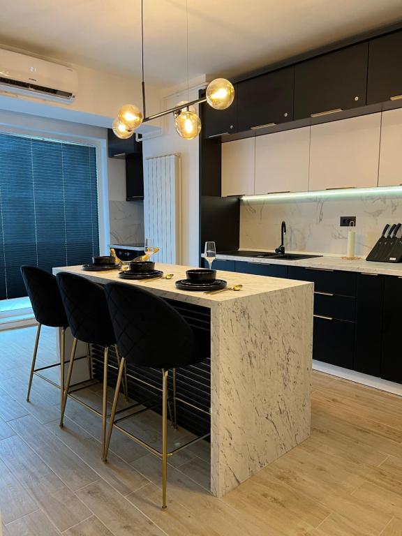 a kitchen with a large island with black cabinets at Elite Summer Suite in Năvodari