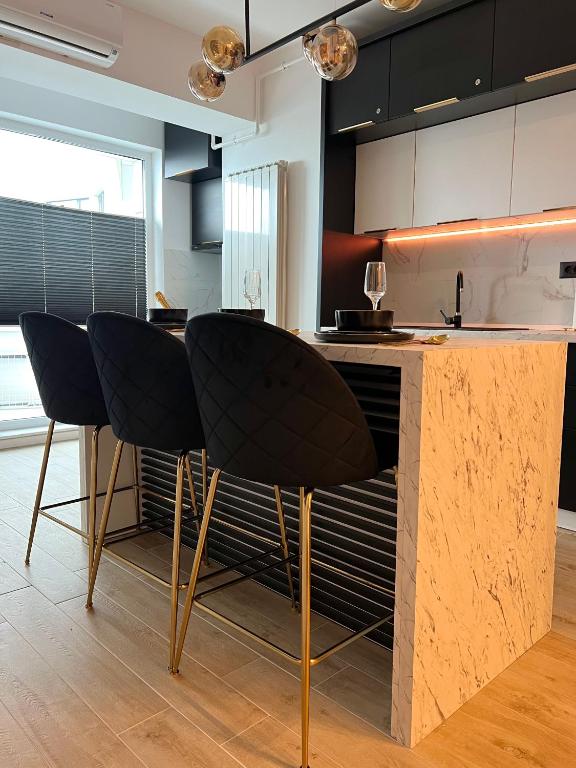 a kitchen with two black chairs at a counter at Elite Summer Suite in Năvodari