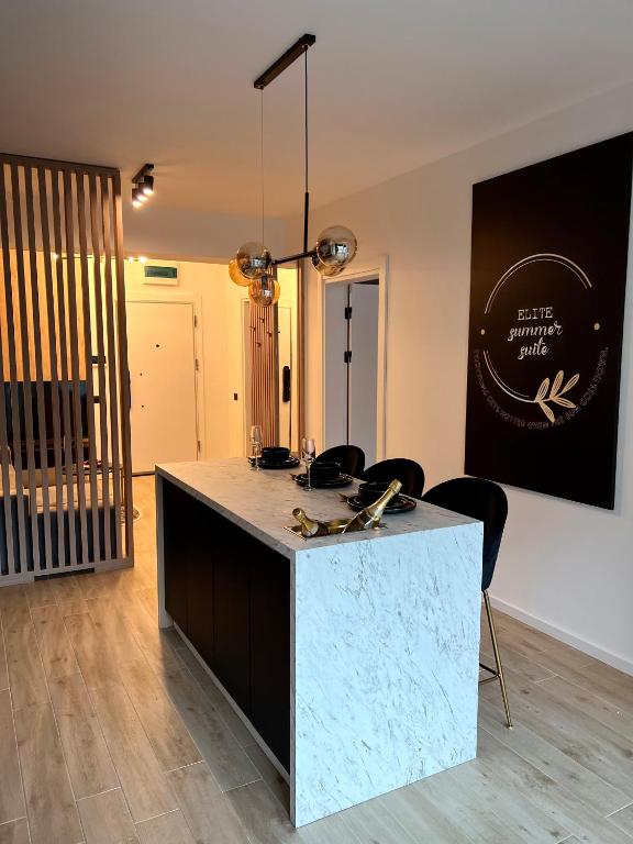 a kitchen with a counter and chairs in a room at Elite Summer Suite in Năvodari