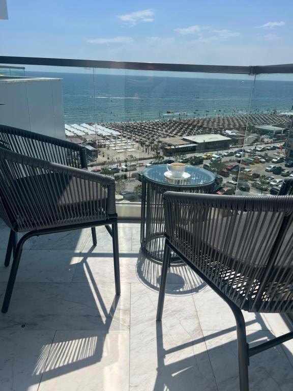 two benches sitting on a balcony looking at the ocean at Elite Summer Suite in Năvodari