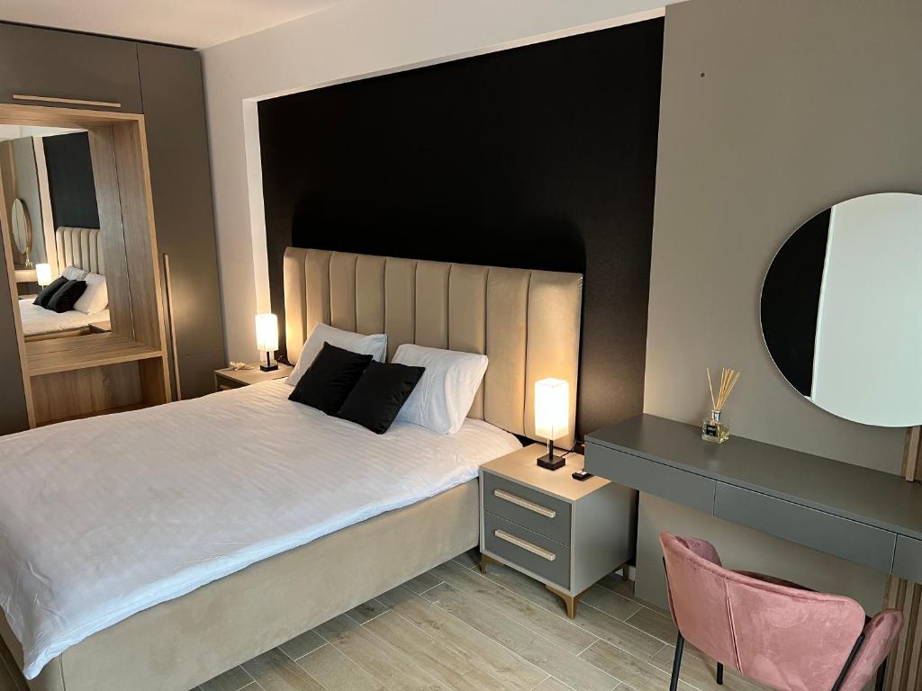 a bedroom with a large bed and a mirror at Elite Summer Suite in Năvodari