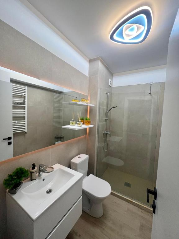 a bathroom with a toilet and a sink and a shower at Elite Summer Suite in Năvodari