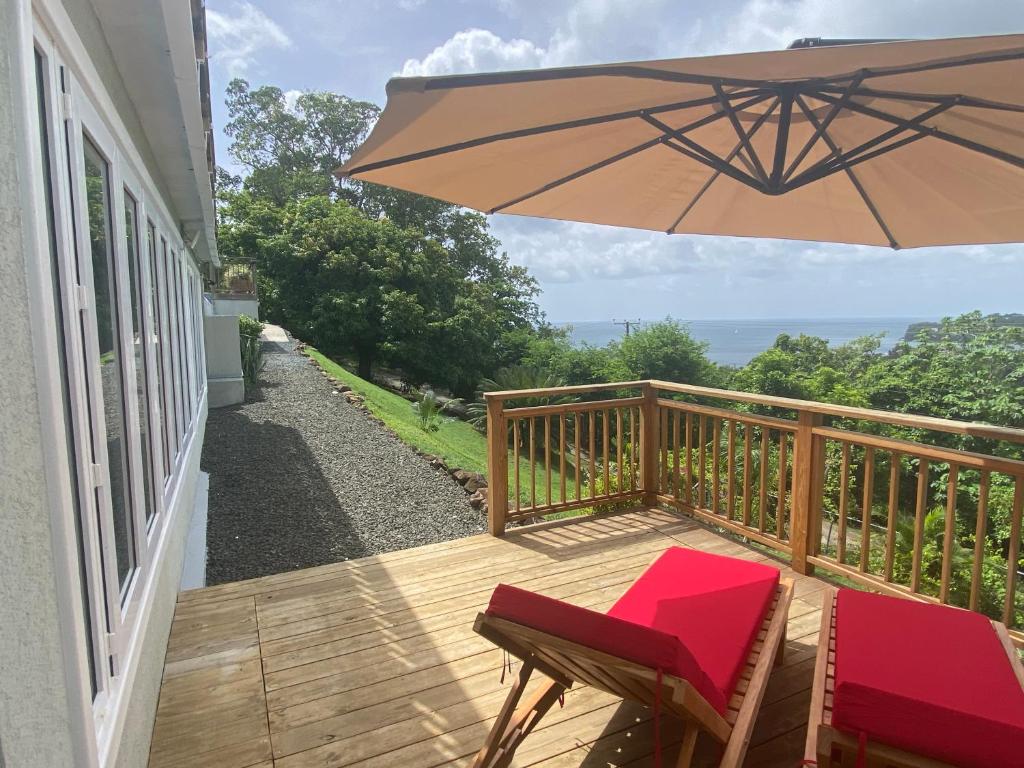 a wooden deck with a chair and an umbrella at Memwa Villas in Castries