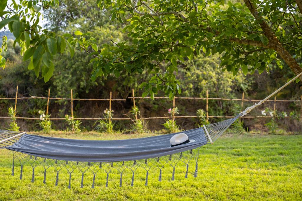 a blue hammock in a field of grass at Agapanthus Retreat in Kouvaláta