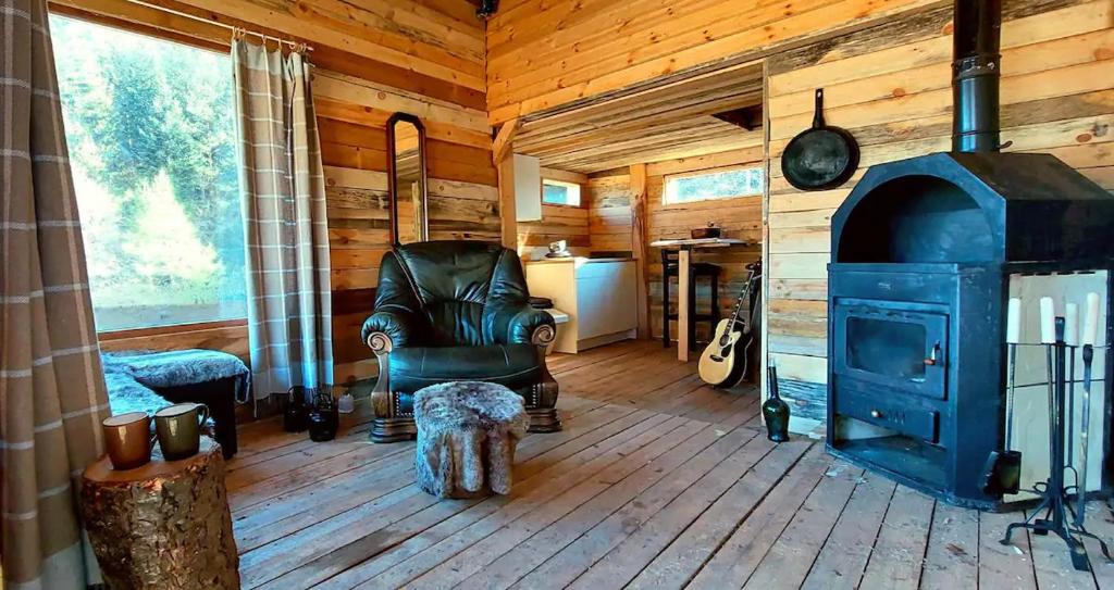 本赫沃的住宿－Unique off-grid cabin in raw nature: Bucephalus，小屋内的客厅设有燃木火炉