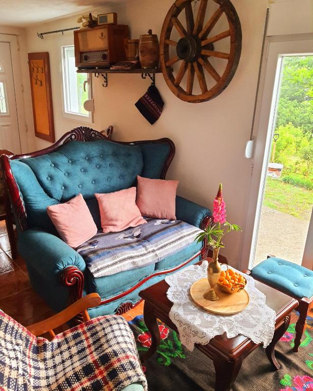 a living room with a blue couch and a table at Guest House Balcak Kolasin in Kolašin