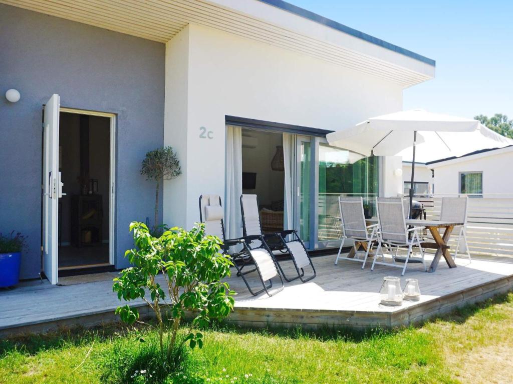 a patio with a table and chairs and an umbrella at Modern Beach Cottage in Tofta, Gotland in Gnisvärd