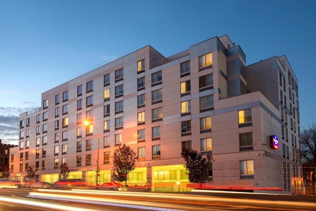 um grande edifício numa rua da cidade à noite em SpringHill Suites by Marriott New York LaGuardia Airport em Queens