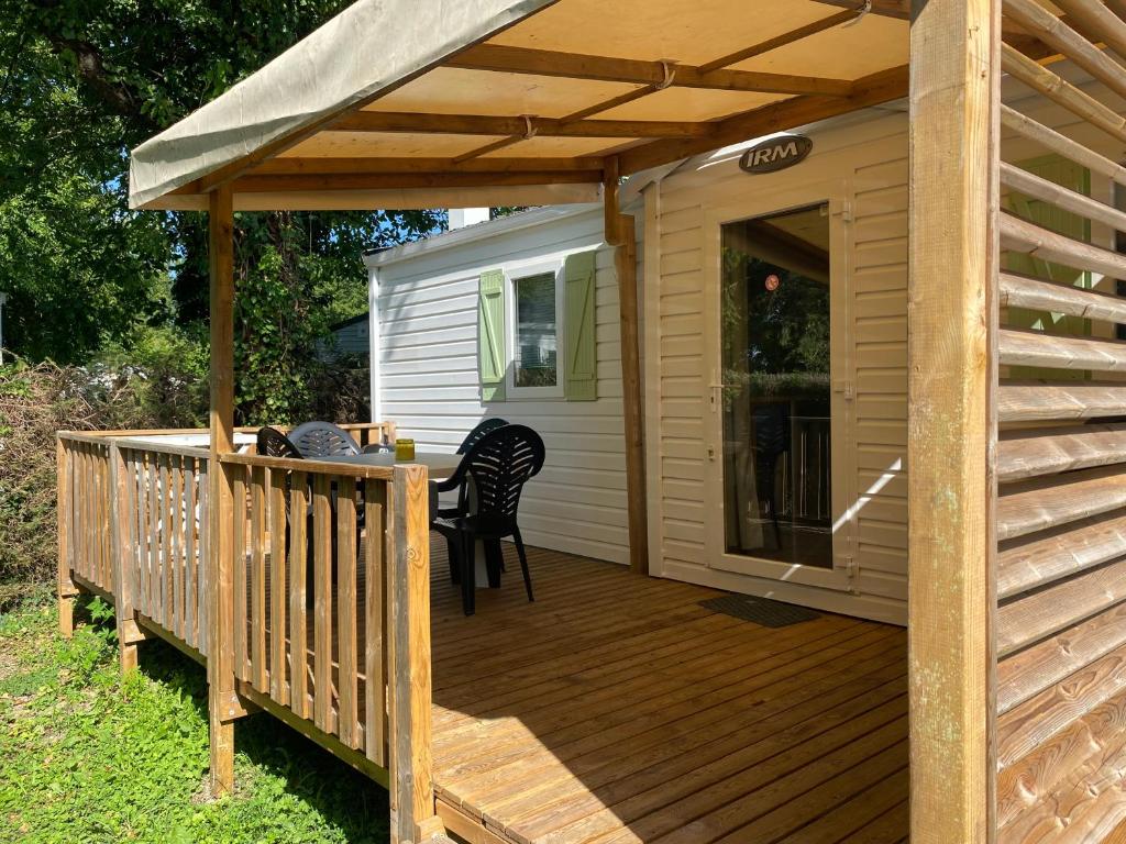 a wooden deck with a pergola and chairs on it at MORREALE MOBILE HOME (prox. Europa park/Rulantica) in Boofzheim