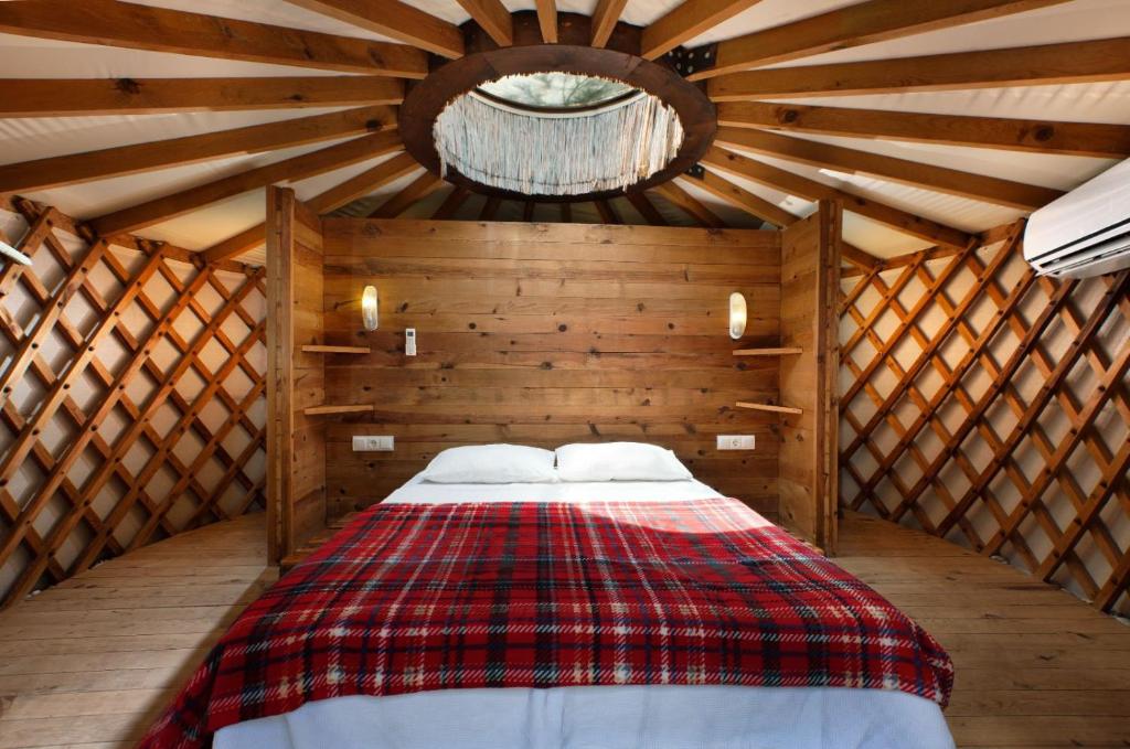 1 dormitorio con 1 cama en una habitación de madera en Chakra Beach Kabak en Faralya