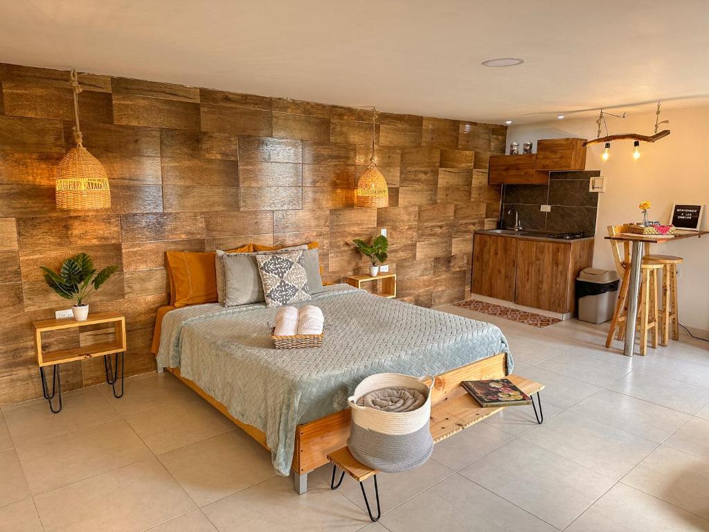 - une chambre avec un lit et un mur en bois dans l'établissement Cabañas con jacuzzi y chimenea - Casa Floral, Marinilla, à Marinilla