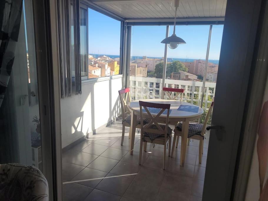 une salle à manger avec une table et des chaises sur un balcon dans l'établissement Appartement, au Cap d'Agde