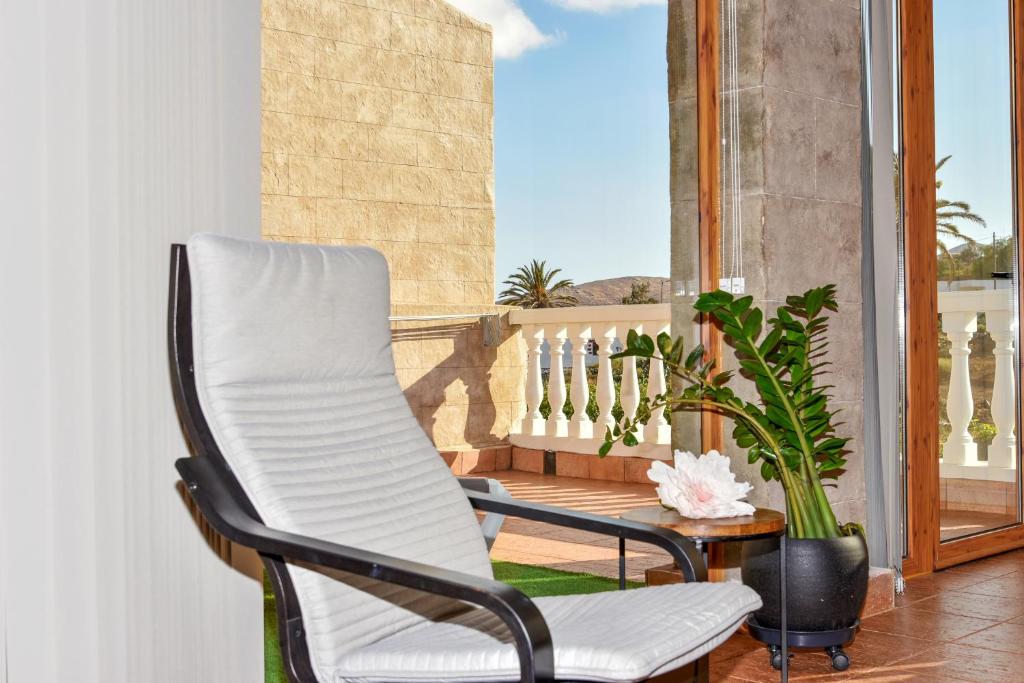 a porch with a white chair and a table at Casa las Estrellas in Agua de Bueyes