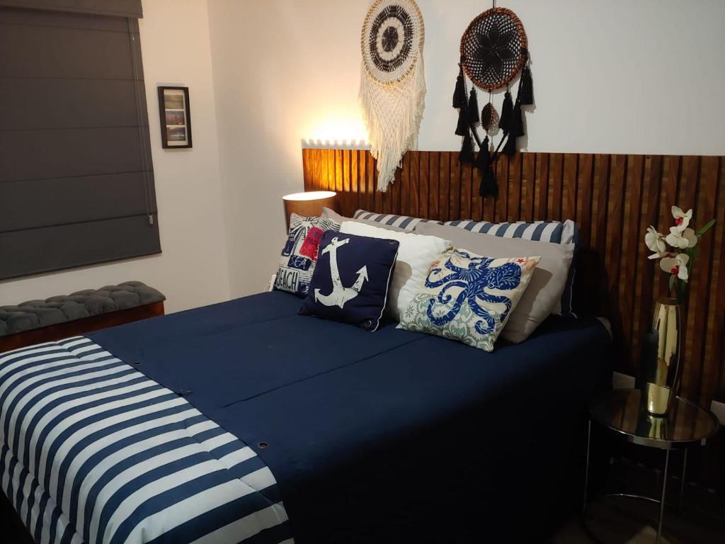 sypialnia z niebieskim łóżkiem z poduszkami w obiekcie Casa “PLAYA DORADA” w mieście Mazatlán