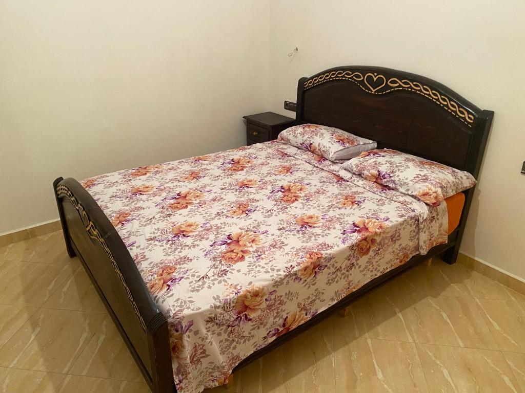 1 Schlafzimmer mit einem Bett mit Blumendecke in der Unterkunft Lotissment oum kaltoum 2 in Martil