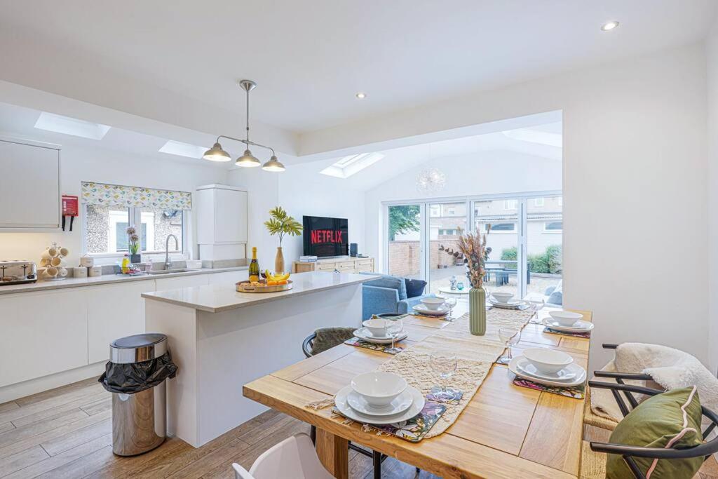 a kitchen and living room with a table and chairs at Beautiful House - Sleeps 8 - Close to City Centre with Free Parking, Fast Wifi and Smart TV with Virgin TV and Netflix by Yoko Property in Northampton