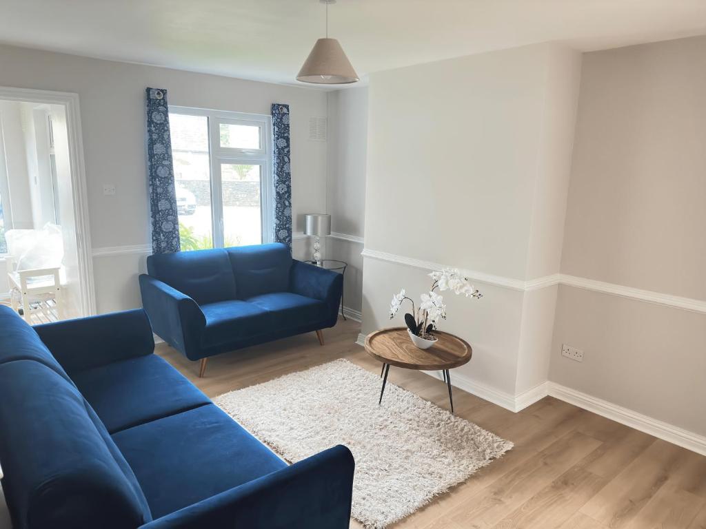 un soggiorno con divano blu e tavolo di Tully's Home, Tulfarris Village, Wicklow a Blessington