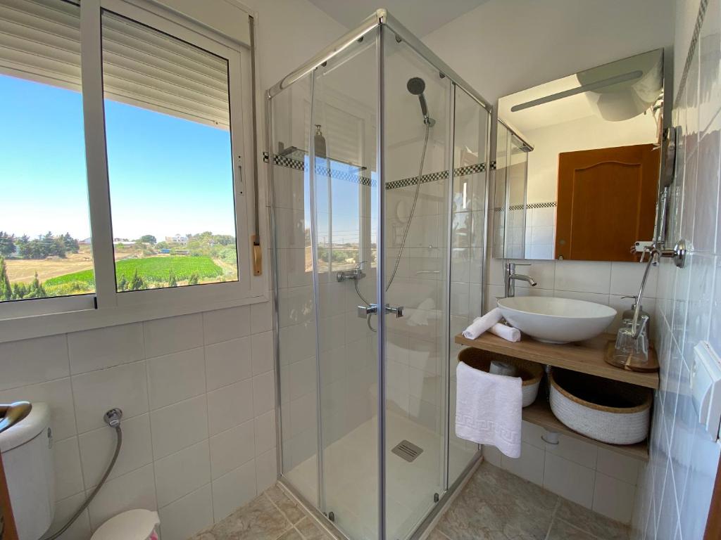 a bathroom with a glass shower and a sink at Alojamiento Rural Al´Mare in Conil de la Frontera