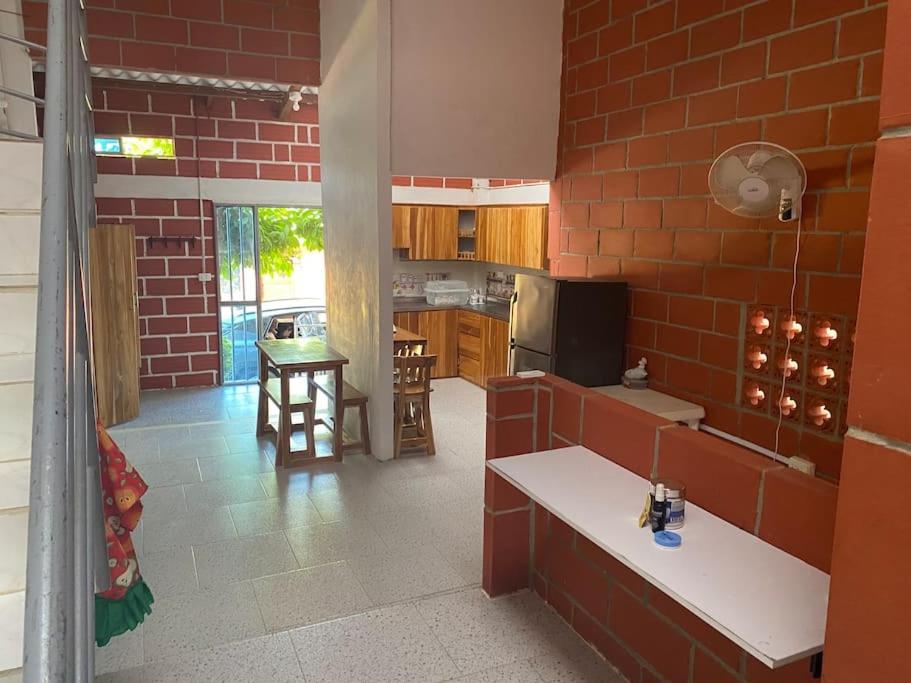 a kitchen with a red brick wall at Villa Celeste in Arboletes