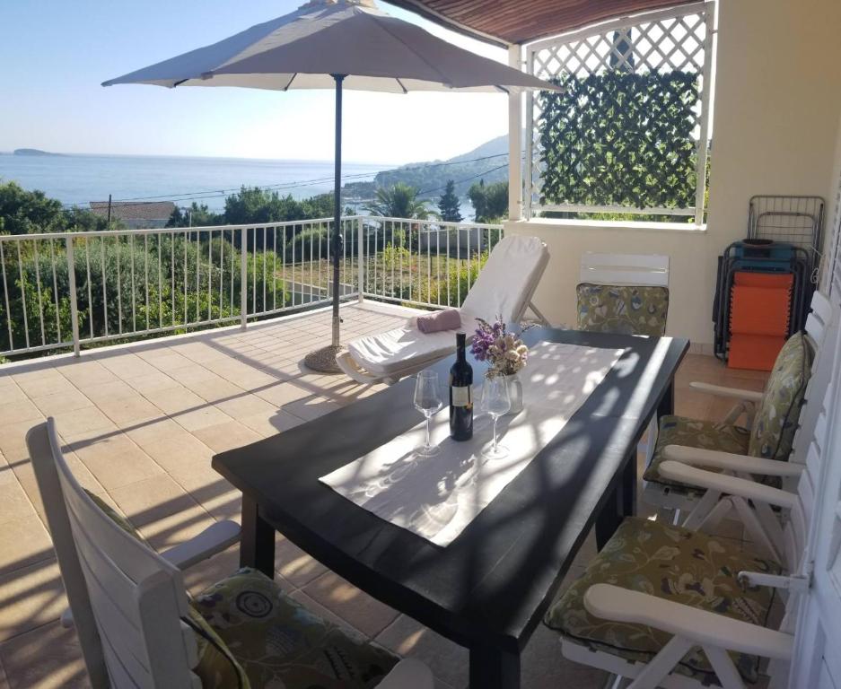 a table with a bottle of wine on a balcony at Apartmani KaLu in Mlini