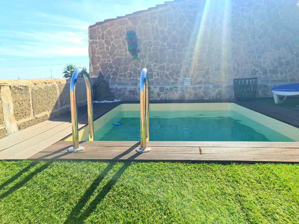 una pequeña piscina con terraza de madera y piscina en Jazmín, en Arico Viejo