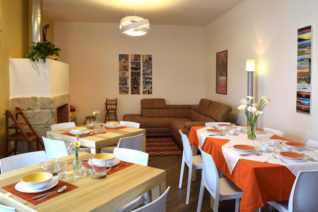 una sala da pranzo con 2 tavoli e un divano di Culummi Bed & Breakfast a Cavallino di Lecce