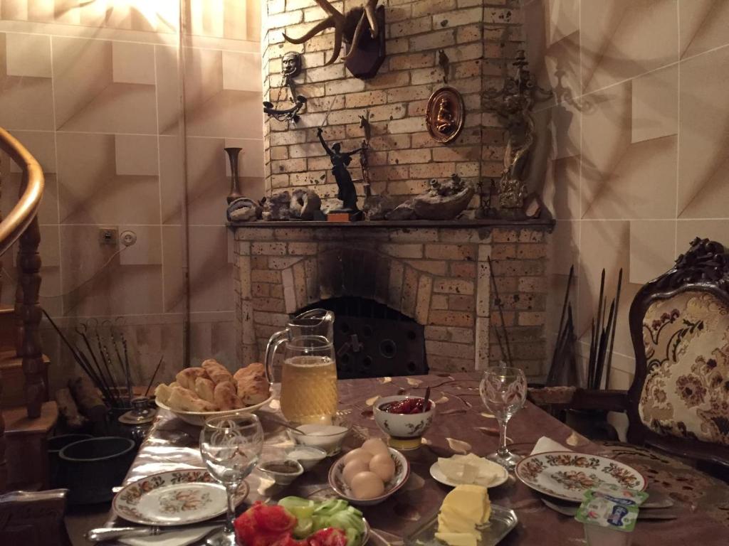 a table with plates of food and a fireplace at Guest House Getahovit in Getahovit