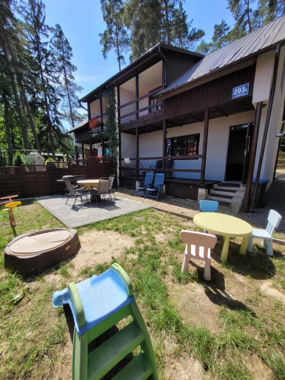 a building with a table and chairs in the yard at Domek murowany w Dolinie Symsarny in Lidzbark Warmiński