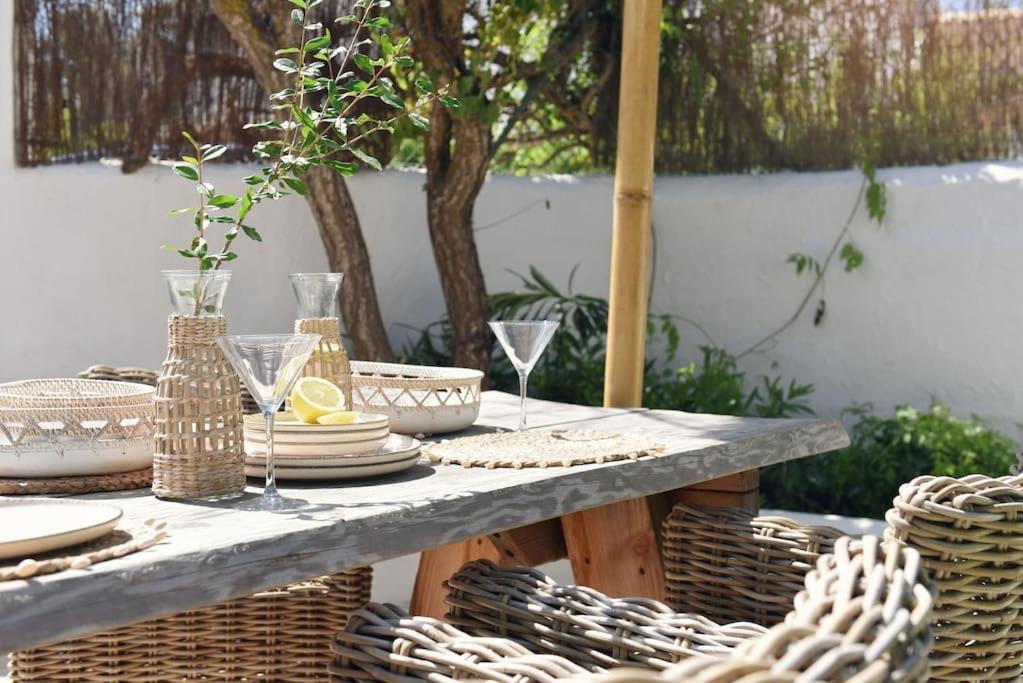 a table with baskets and plates and wine glasses at Casa dos Islas Loft in San Antonio Bay