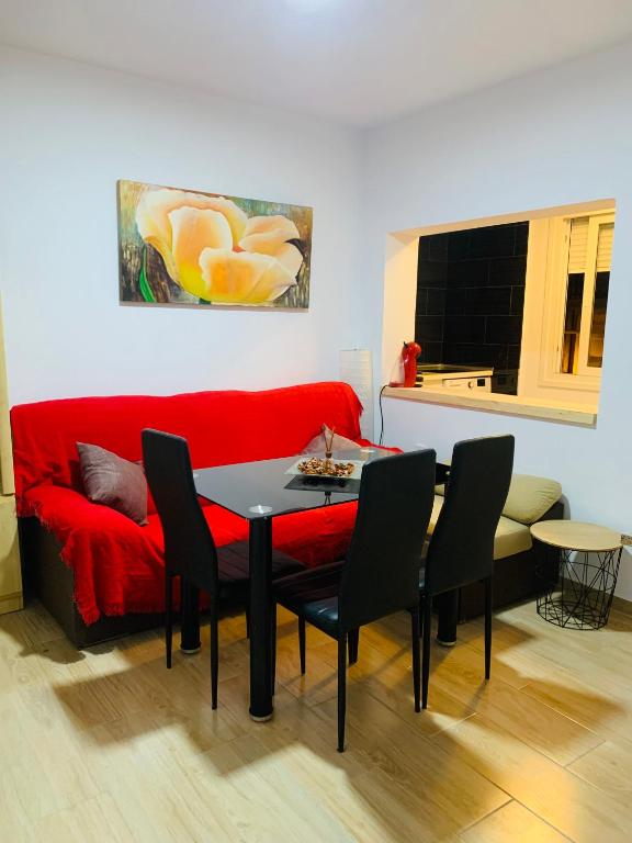a living room with a red couch and a table at Apartamento Delfin - Punta Umbria in Punta Umbría