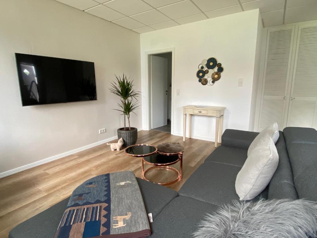 a living room with a couch and a flat screen tv at Angenehmes Wohnen in Bad Bramstedt Appartement II in Bad Bramstedt