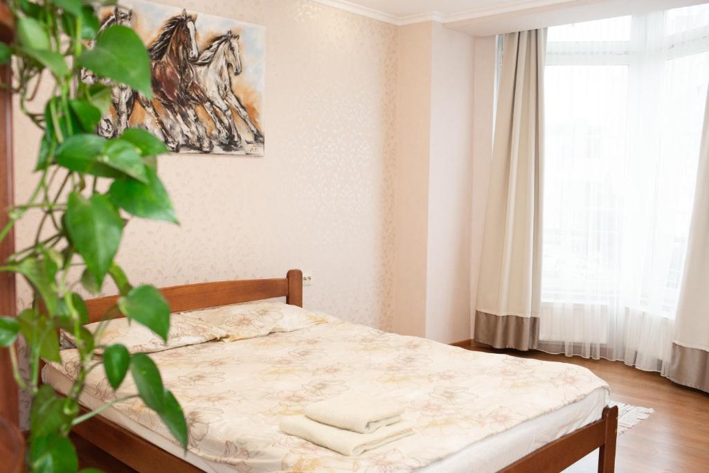 1 dormitorio con cama y planta en Апартаменти на Сихові 3й, en Leópolis