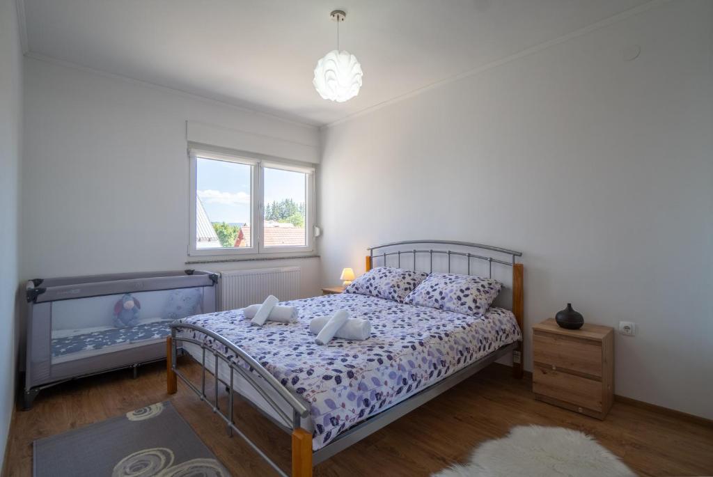 a bedroom with a bed and a window at Apartman Josip in Gospić