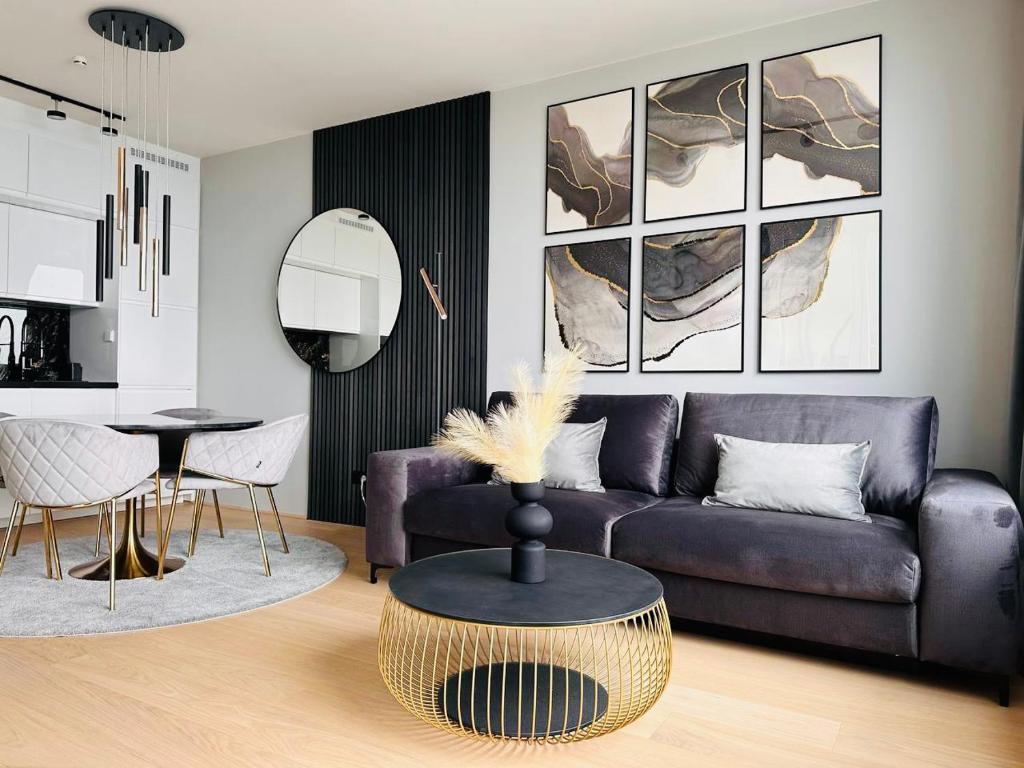 ein Wohnzimmer mit einem lila Sofa und einem Tisch in der Unterkunft high-end apartment close to metro and uno-city with e-parking in Wien