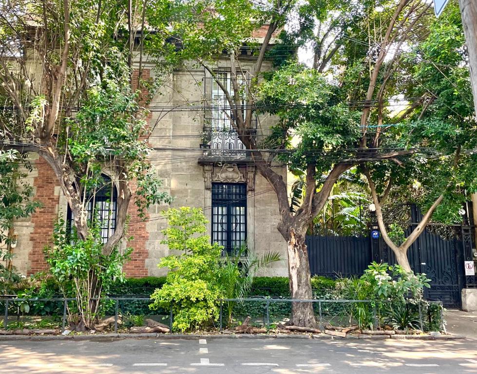 a brick building with a tree in front of it at Maison du comte in Mexico City