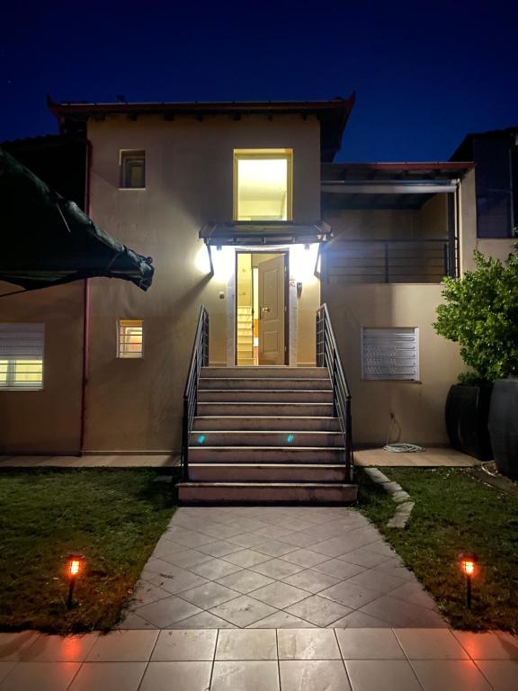 een huis met een trap die 's nachts naar een deur leidt bij Villa Beauty in Paliouri