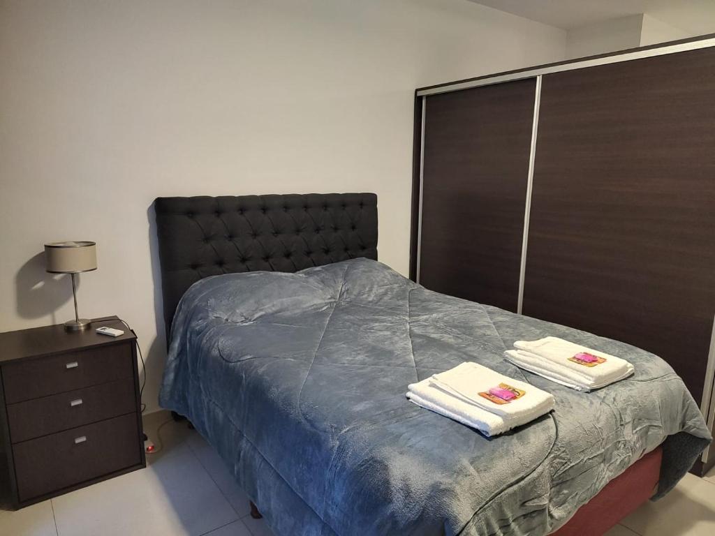 a bedroom with a bed with two towels on it at Monoambiente San Isidro in San Juan
