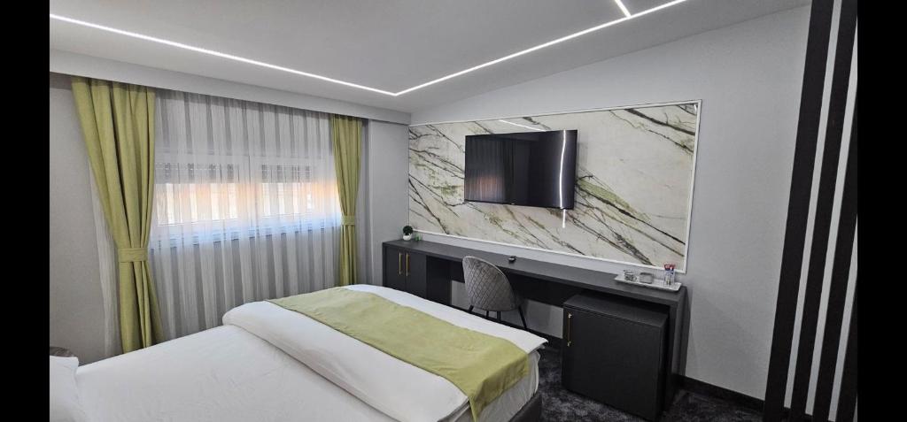 Cette chambre comprend un lit et une télévision murale. dans l'établissement Luxury Room 's, à Velika Kladuša